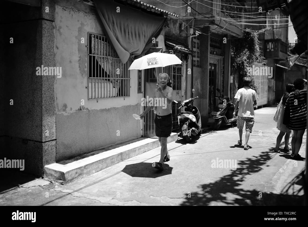 The old man who passed by with an umbrella on the streets of the old city. Stock Photo