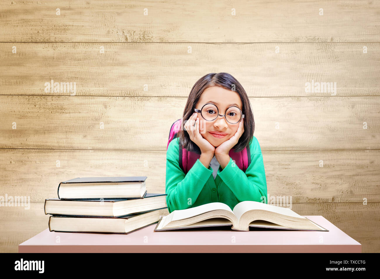 Asian cute girl with glasses and backpack with books on the desk with ...