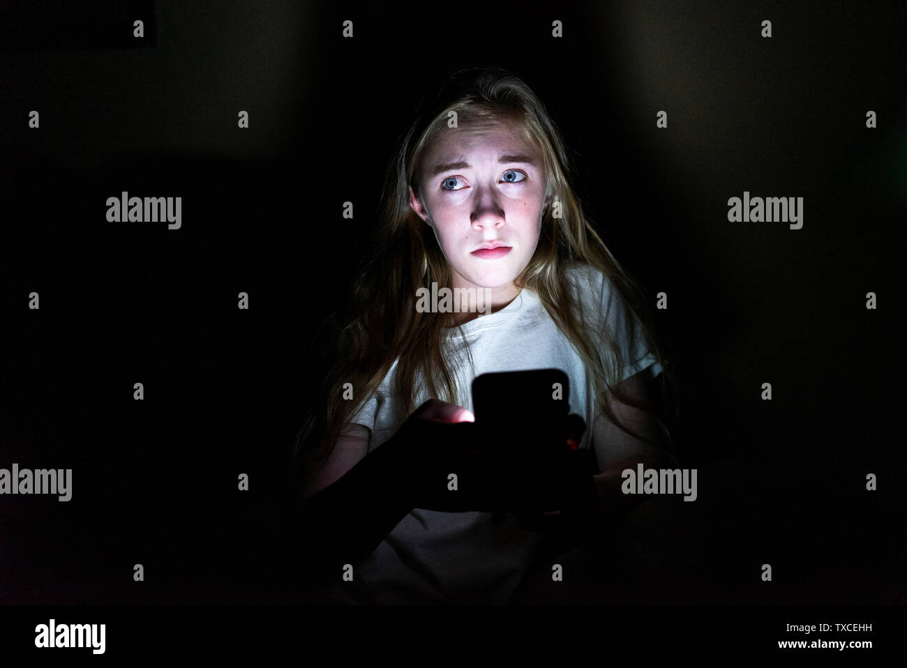 Upset Girl Sitting In The Dark While Using Her Smartphone The Light From The Screen Is Illuminating Her Face Stock Photo Alamy Upset Girl Sitting In The Dark While Using Her Smartphone The Light From The Screen Is Illuminating Her Face Stock Photo Alamy