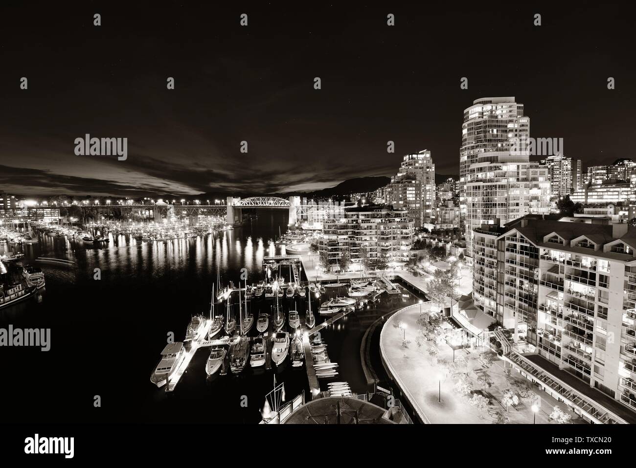 Vancouver harbor view with urban apartment buildings and bay boat at dusk in Canada Stock Photo