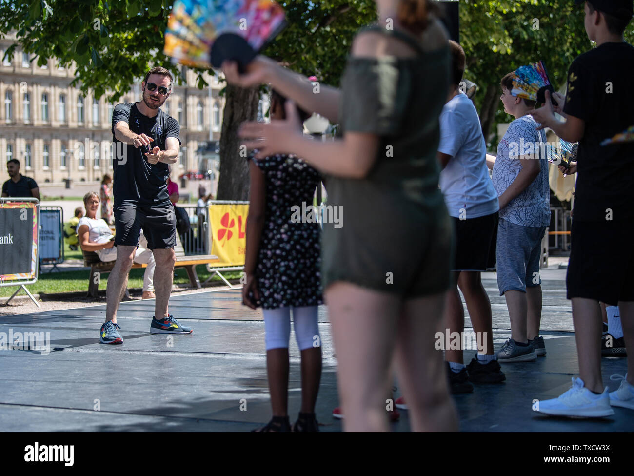 Stuttgart, Germany. 24th June, 2019. Eric Gauthier, director of the Compagnie Gauthier Dance, dances with a school class on the Schlossplatz in Stuttgart. The third edition of the 18-day dance festival 'Colours' presents 20 productions in the Theaterhaus in addition to public workshops, dance teas and performances in the city centre. Credit: Fabian Sommer/dpa/Alamy Live News Stock Photo