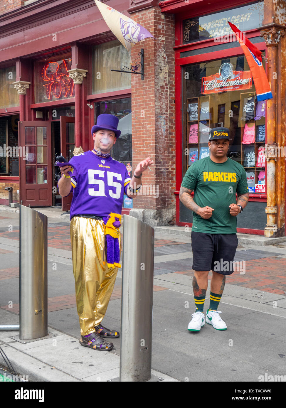 Minnesota Vikings and Green Bay Packers football fans on Broadway at NFL Draft 2019 Nashville Tennessee. Stock Photo