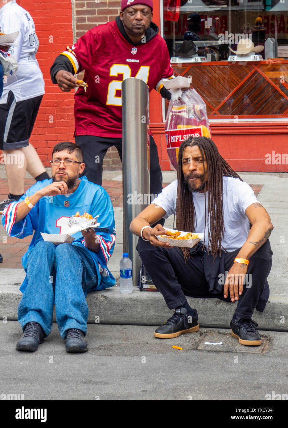 Men eating food bought from a food truck on Broadway at the NFL Draft 2019 Nashville Tennessee USA. Stock Photo