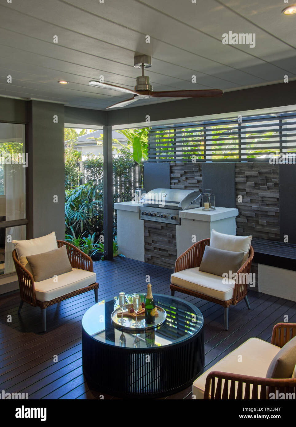 Alfresco sitting area with BBQ table and chairs wooden floorboards