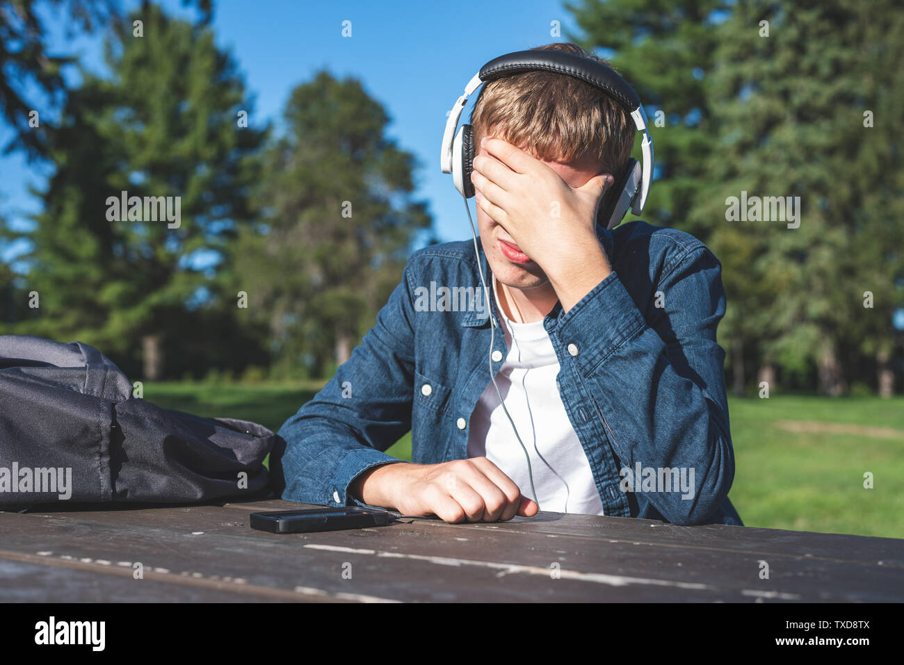 Teenage son listening music in headphones or playing online games ignoring  his mother Stock Photo - Alamy