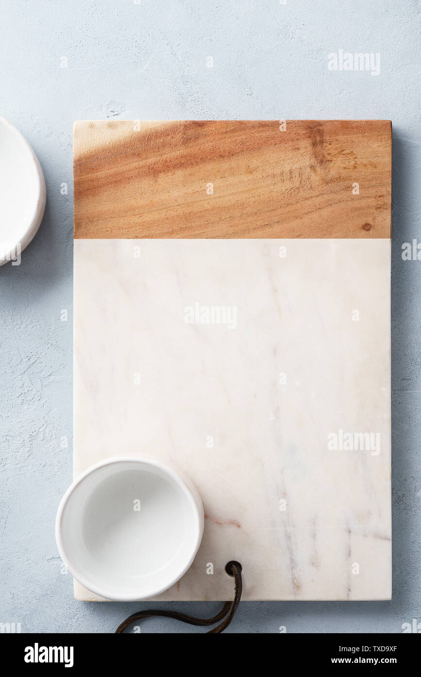 Rectangular marble and wooden serving board and a bowl. Empty space for text. Top view. Stock Photo