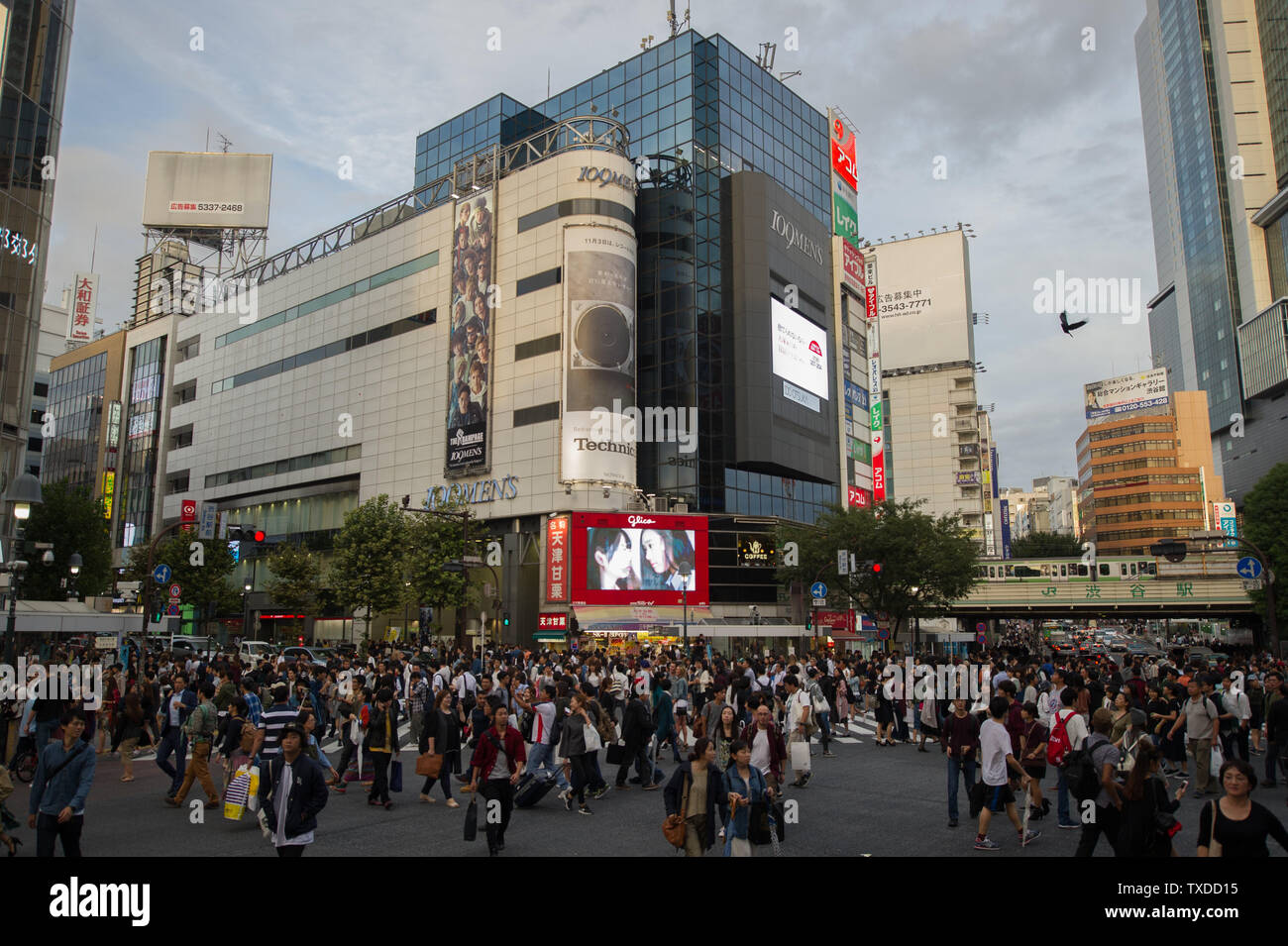 Shibuya Crossing in Tokyo, Japan, is famous for it's extremely busy scramble crosswalk, with pedestrians crossing in all directions at one time. Stock Photo