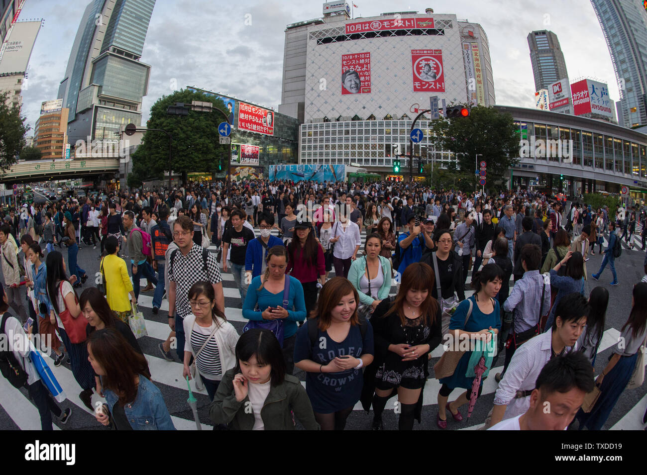 Shibuya Crossing in Tokyo, Japan, is famous for it's extremely busy scramble crosswalk, with pedestrians crossing in all directions at one time. Stock Photo