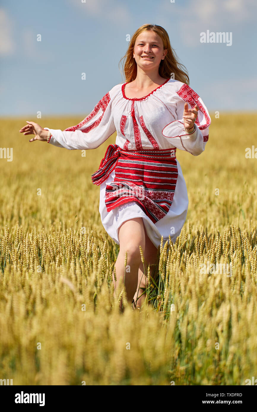 Romanian girl in traditional costume in a wheat field Stock Photo