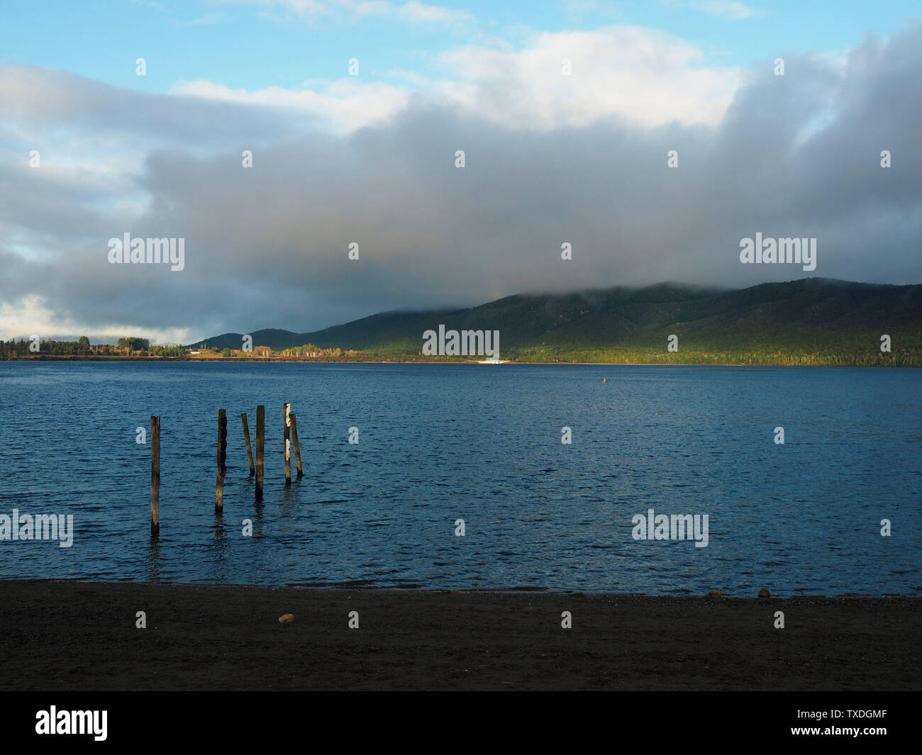 The sun shines on the azure Lake Te Anau on a cloudy morning Stock Photo