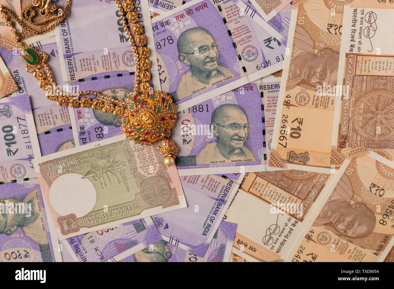 Concept of black money, IT raid, confiscated Money showing Indian currency notes with jewelry. Stock Photo