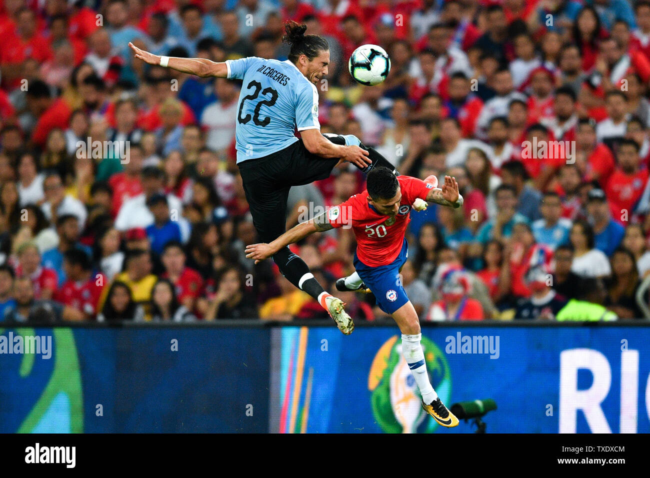 Rio De Janeiro, Brazil. 24th June, 2019. Uruguay's Martin Caceres (L) vies with Charles Aranguiz of Chile during the Copa America 2019 Group C match between Uruguay and Chile in Rio de Janeiro, Brazil, June 24, 2019. Uruguay won 1-0. Credit: Xin Yuewei/Xinhua/Alamy Live News Stock Photo