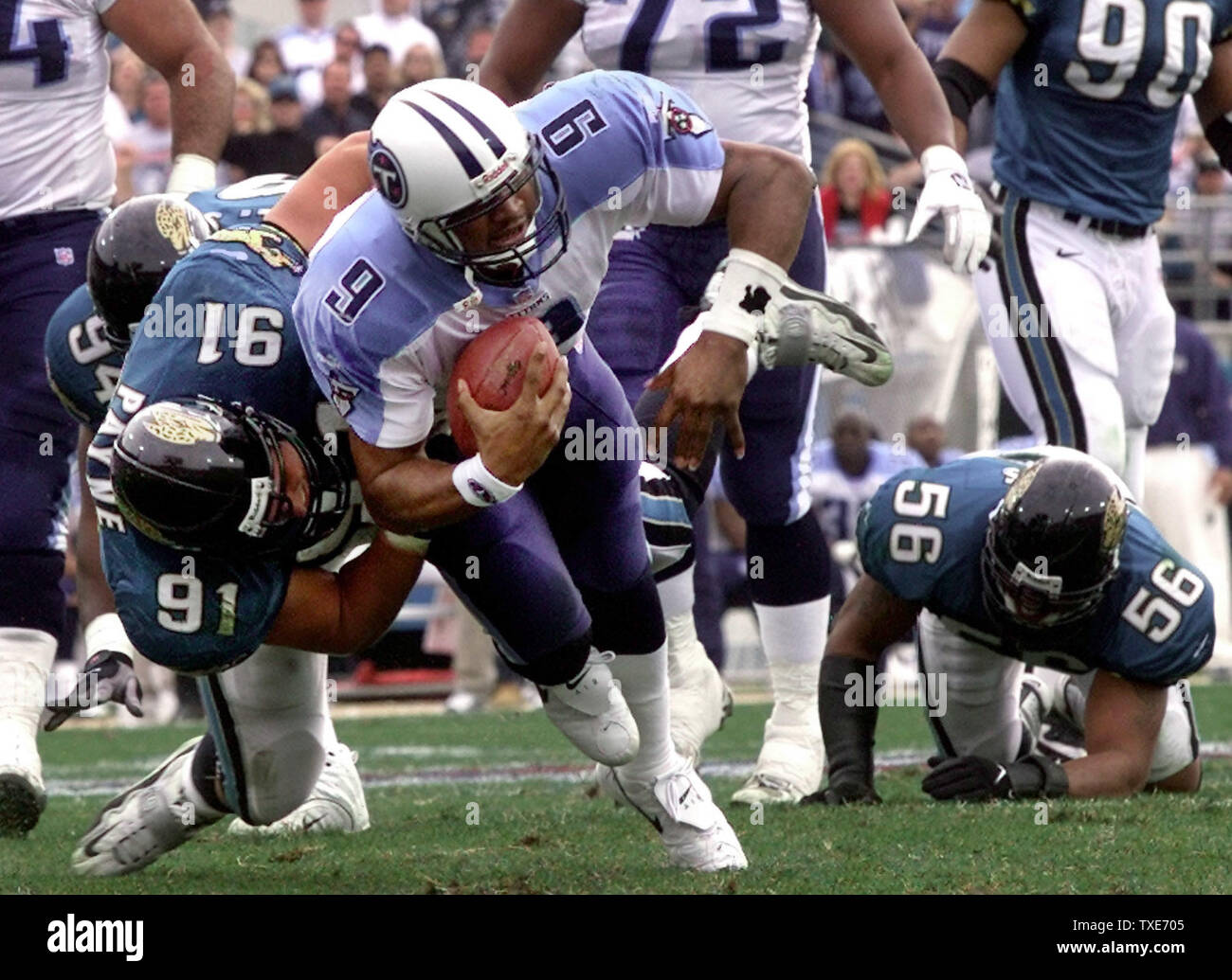 JAX2000012303 - 23 JANUARY 2000 - JACKSONVILLE, FLORIDA, USA:  Jacksonville's defensive tackle Seth Payne (91) drags Tennessee's  quarterback Steve McNair (9) down during first quarter AFC Championship  game action at Alltel Stadium