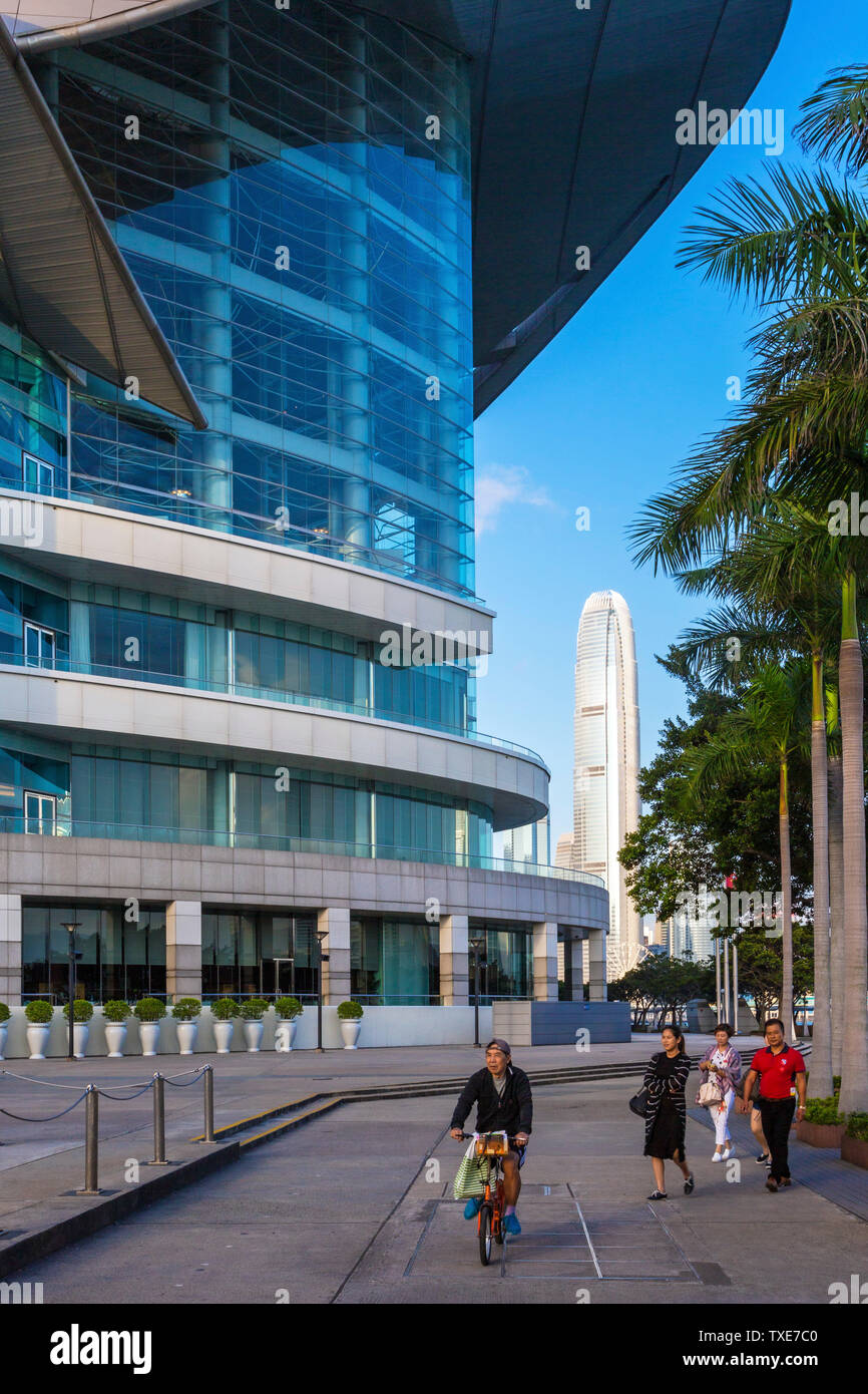 Cyclist and tourists at Convention and Exhibition Centre, Hong Kong, SAR, China Stock Photo