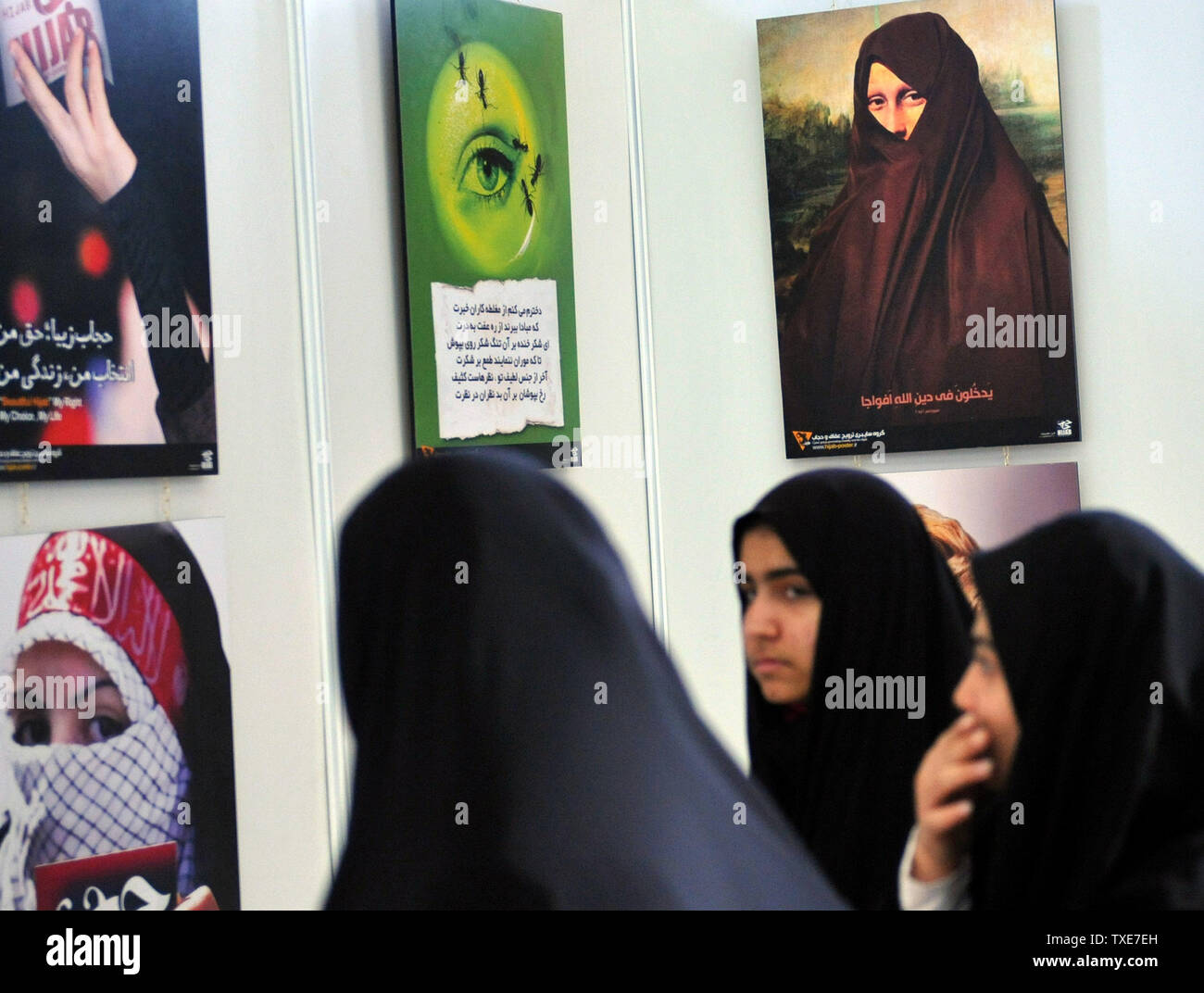 Iranian women look at copies of Leonardo Da Vinci's painting Mona Lisa during the International Koran Exhibition is seen at the Imam Khomeini Grand Mosque during the holy month of Ramadan on August 16, 2010 in Tehran, Iran.     UPI/Maryam Rahmanian. Stock Photo