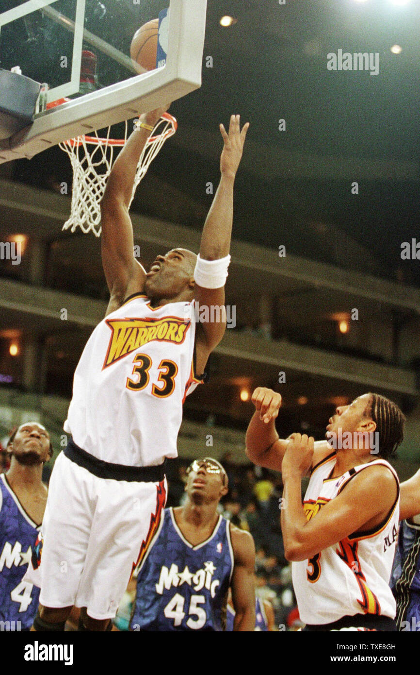 OCP2000010901 - 09 JANUARY 2000 - OAKLAND, CALIFORNIA, USA: Seattle  Supersonics' Horace Grant (54) goes for a shot against Golden State Warriors'  Adonal Foyle (31) and Antawn Jamison (R) in the first