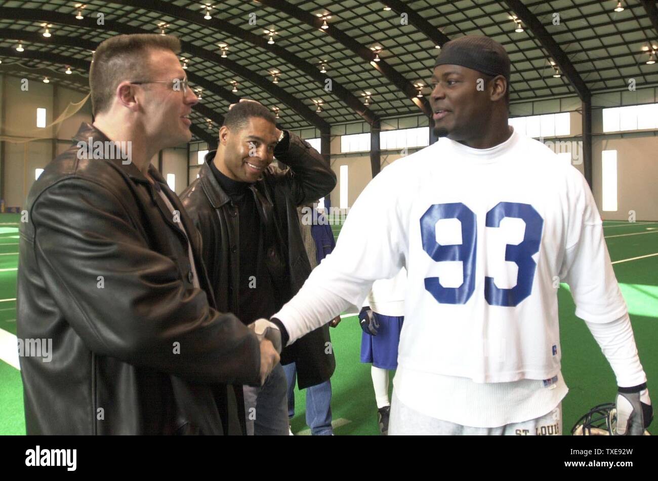 SLP2000012107- 21 JANUARY 2000- EARTH CITY, MISSOURI, USA: Former NFL  players turned broadcasters Howie Long and Marcus Allen meet St. Louis Rams  Kevin Carter after practice at Rams Park, January 21. The