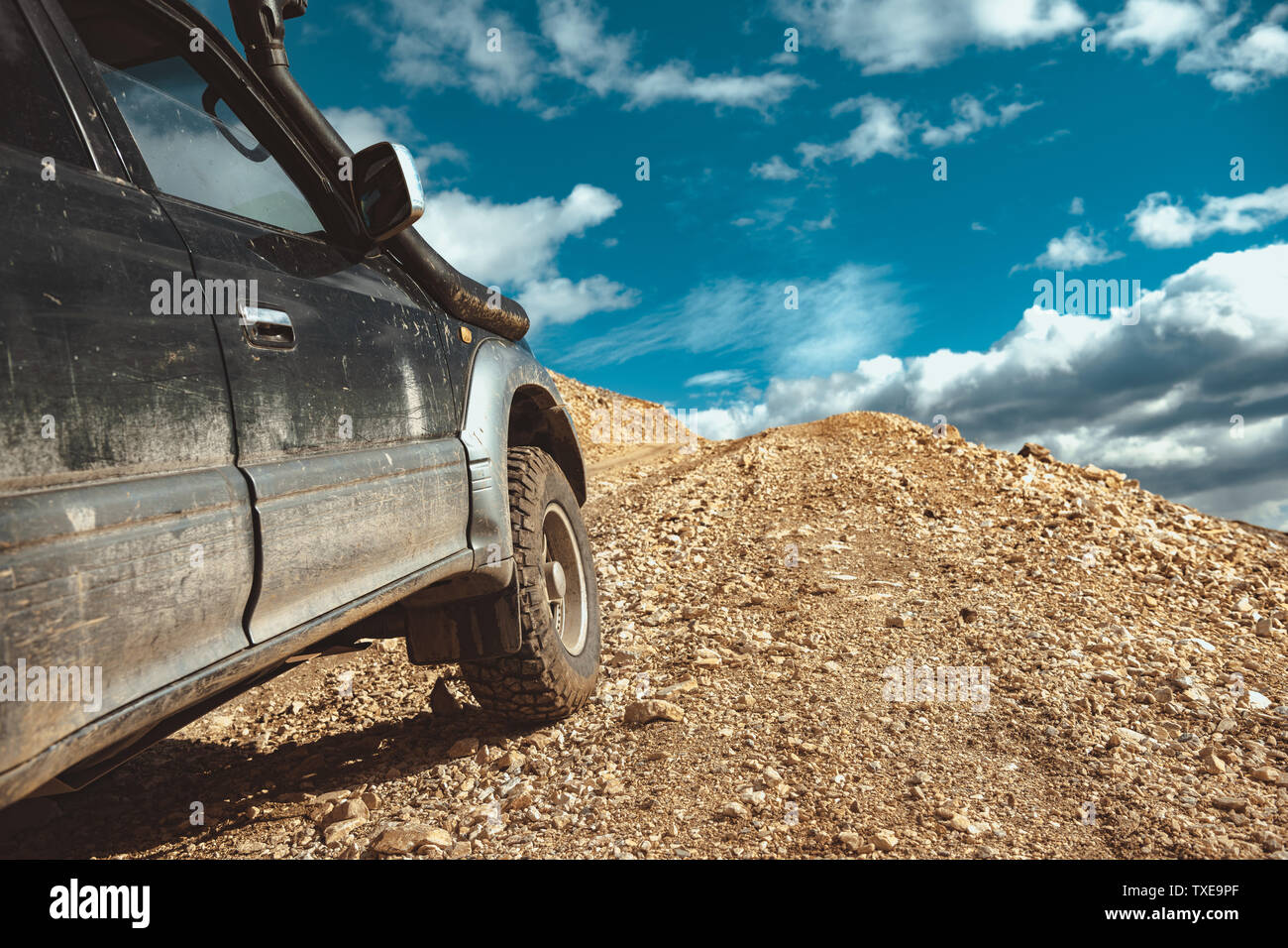 4x4 off road ready car is driving uphill. Close Up photo of wheels