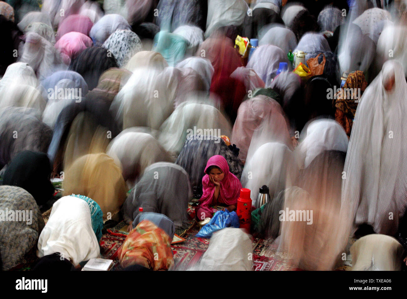 A girl looks on while other women pray during the Lailat al-Qadr (Night of Power) ceremonies which celebrate the night in which the holy Koran was first revealed to the Prophet Mohammed through the angel Gabriel in a mosque in Kabul, Afghanistan on September 10, 2009. Observant Muslims pray all night long for mercy and salvation in a ritual known locally as 'Ehyaa' or 'Revival', one of the most important ceremonies of the holy month of Ramadan.  UPI/Mohammad Kheirkhah Stock Photo