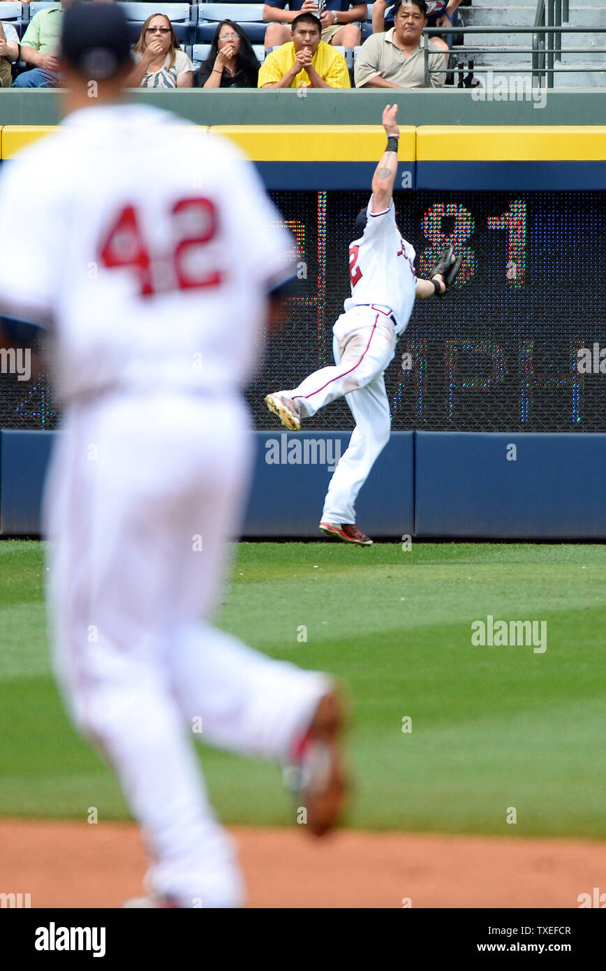 Atlanta Braves left fielder Jonny Gomes (R) fields the pop fly by Miami