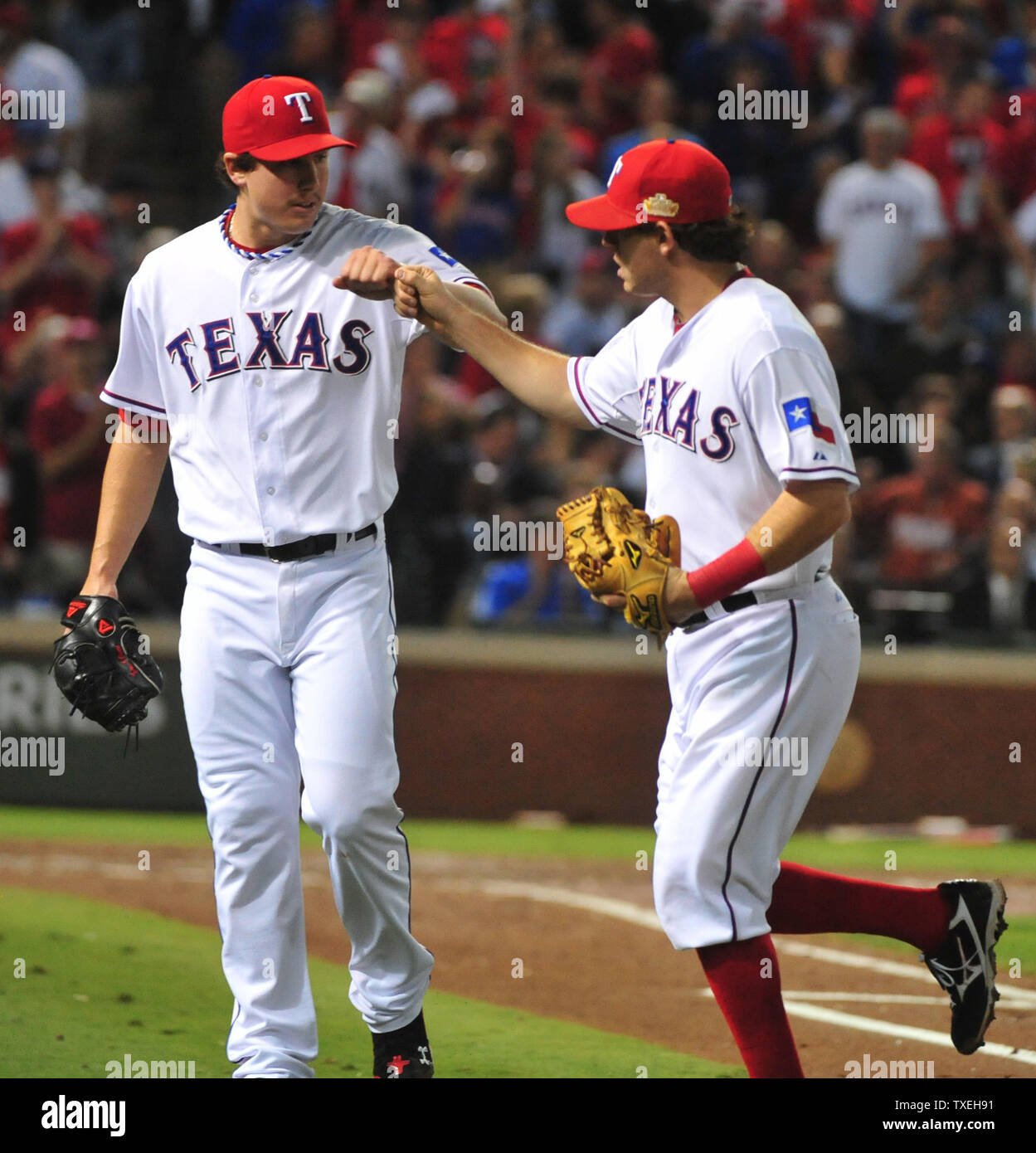 Texas Rangers pitcher Derek Holland (L) bumps fists with Ian Kinsler as  they leave the field in the second inning against the St. Louis Cardinals  in game 4 of the World Series