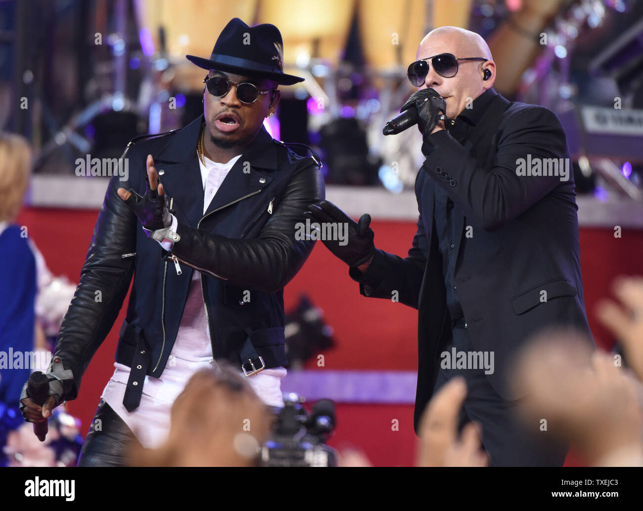 Rappers Ne-Yo and Pittbull perform during halftime of the Dallas Cowboys and Oakland Raiders game at AT&T Stadium in Arlington, Texas on November 27, 2014. For the past 17 years the Dallas Cowboys Thanksgiving Day halftime show has officially launched the Red Kettle Christmas Campaign on a national stage. Since the partnership began in 1997, the annual Red Kettle campaign has raised more than $1.75 billion, which has helped the Army to serve 30 million people each year.   UPI/Ian Halperin Stock Photo