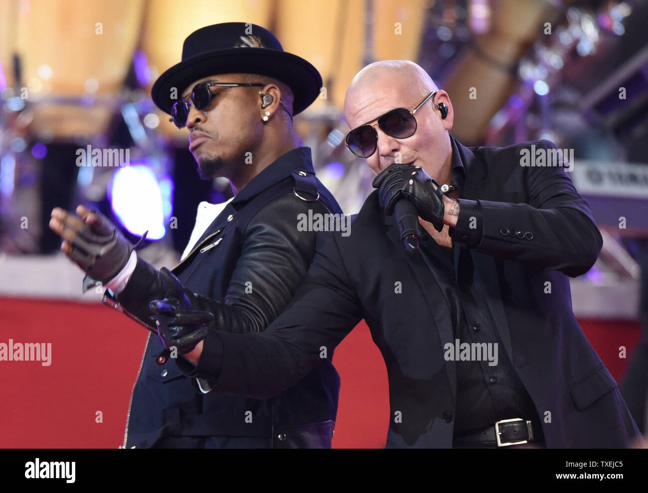 Rappers Ne-Yo and Pittbull perform during halftime of the Dallas Cowboys and Oakland Raiders game at AT&T Stadium in Arlington, Texas on November 27, 2014. For the past 17 years the Dallas Cowboys Thanksgiving Day halftime show has officially launched the Red Kettle Christmas Campaign on a national stage. Since the partnership began in 1997, the annual Red Kettle campaign has raised more than $1.75 billion, which has helped the Army to serve 30 million people each year.   UPI/Ian Halperin Stock Photo
