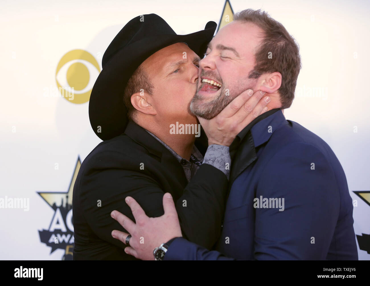 Singer Garth Brooks, left, kisses Lee Brice as they arrive at the 50th