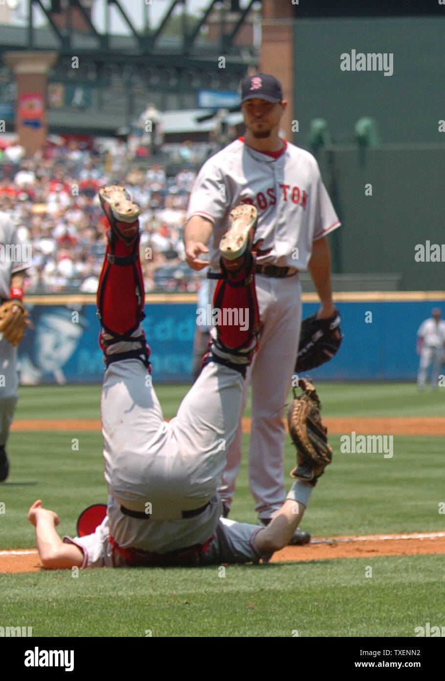 Boston Red Sox catcher Jason Varitek is feet up on the first base line after falling while trying to field a pop fly hit by Atlanta Braves Jeff Francoeur in the third inning June 17, 2006, in Atlanta's Turner Field. Boston pitcher Josh Beckett look on. The Red Sox defeated the Braves 5-3 (UPI Photo/John Dickerson) Stock Photo