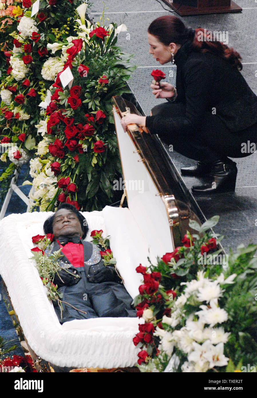 Singer James Brown's companion Tomi Rae Hyni, who lived with the singer and  often performed with his band, kneels above his casket at the funeral  service for Brown at the James Brown