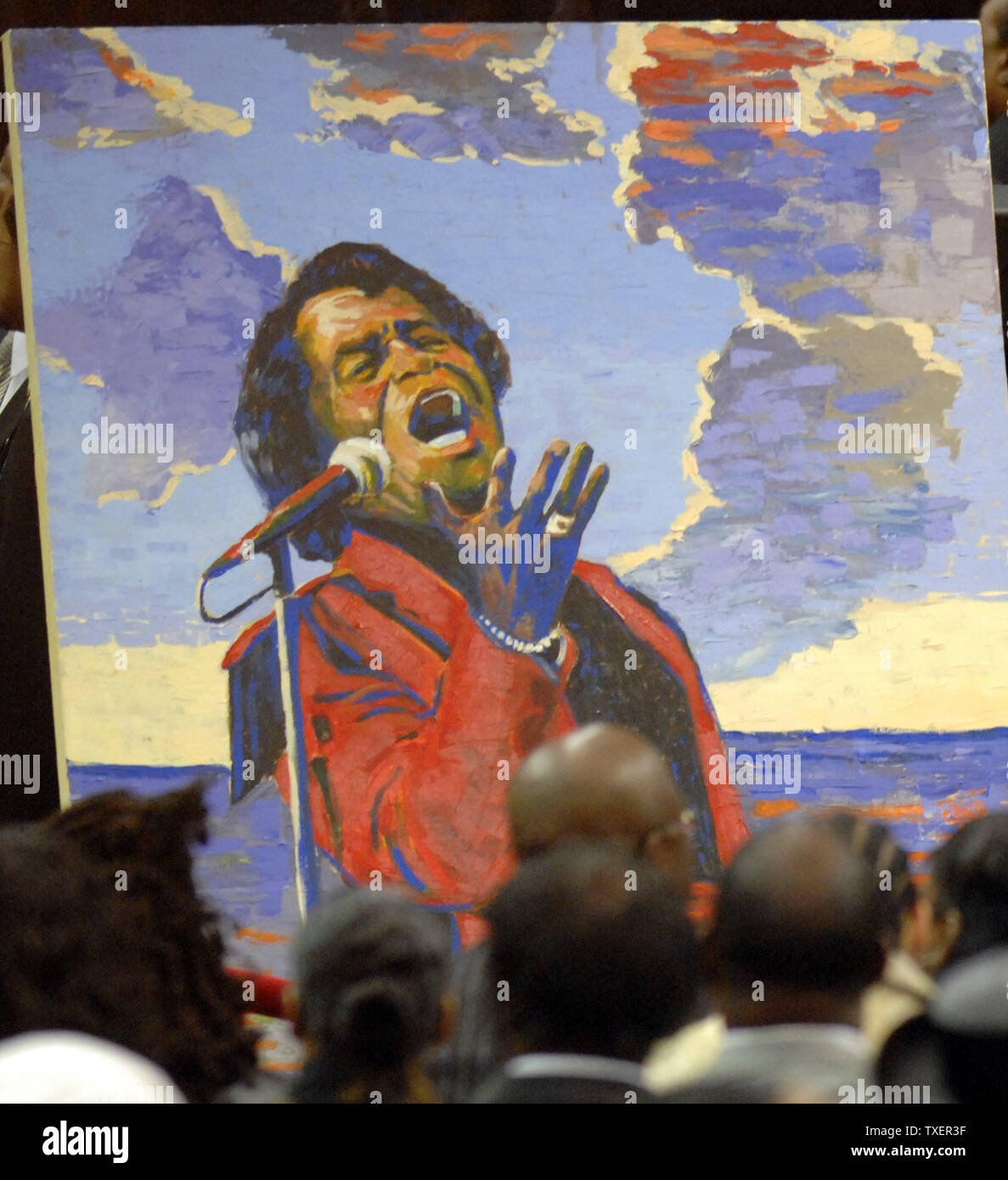 A portrait of James Brown makes a backdrop for mourners viewing his