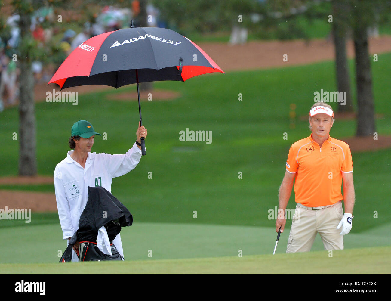 Bernhard Langer and caddie Terry Holt stand in the rain on the front nine in the fourth round of the Masters at Augusta National on April 14, 2013 in Augusta, Georgia.  UPI/Kevin Dietsch Stock Photo