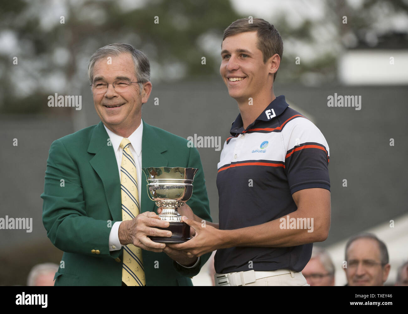 Augusta National chairman Billy Payne presents Oliver Goss with the low