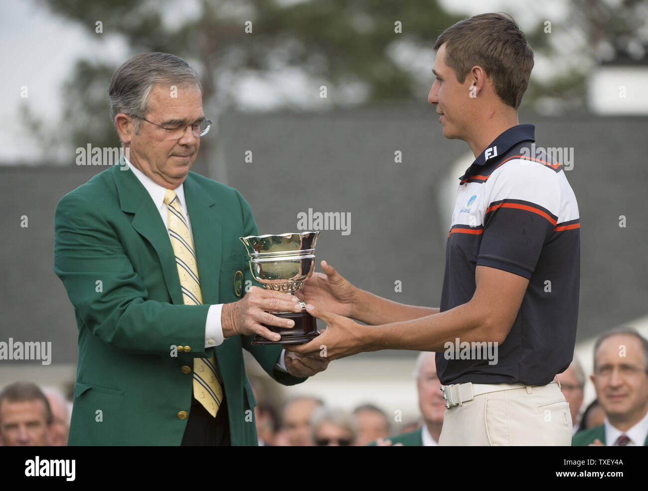 Augusta National chairman Billy Payne presents Oliver Goss with the low