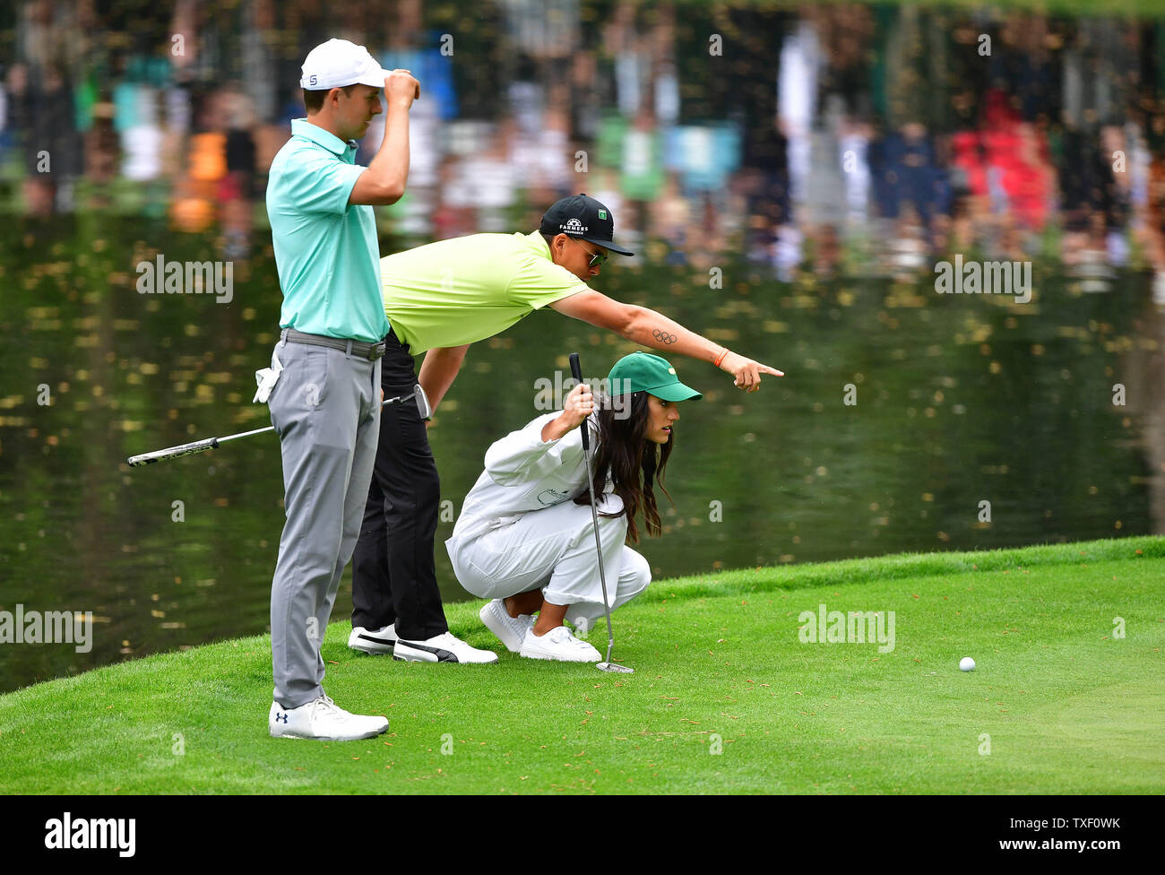 Rickie Fowler C Helps His Girlfriend Allison Stokke Line Up A Putt As Jordan Spieth Watches During The Par 3 Contest At The 2018 Masters Tournament At The Augusta National Golf Club