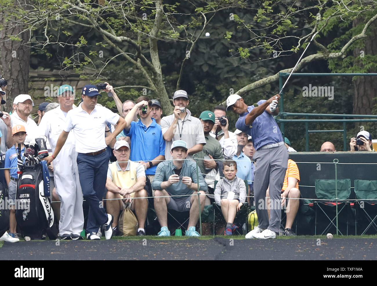 Patrons watch Tiger Woods hit his tee shot on the 16th tee box at practice on the Monday before the 2019 Masters Tournament at Augusta National Golf Club in Augusta Georgia on
