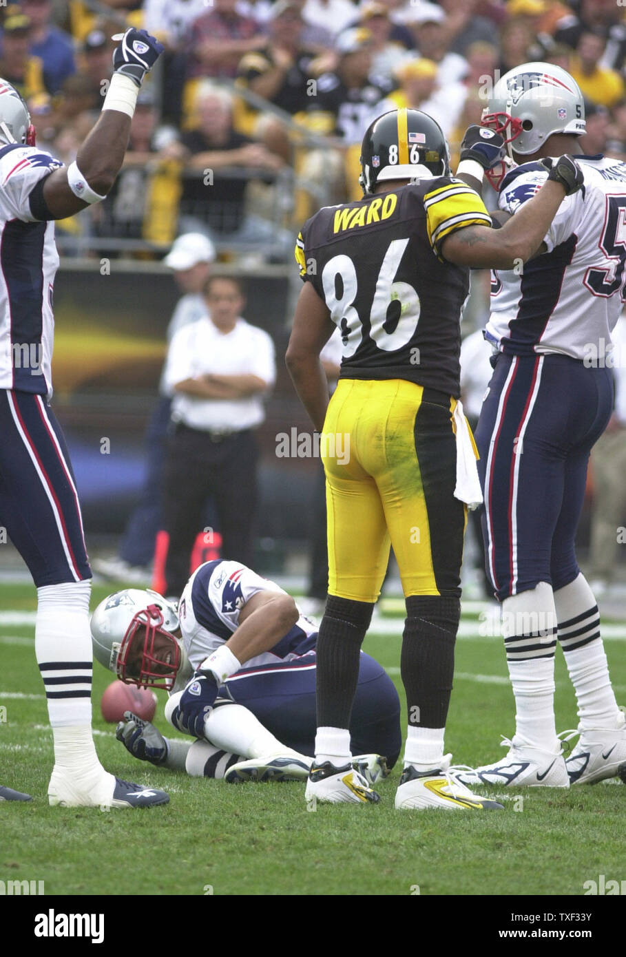 Pittsburgh Steelers Hines Ward and New England Patriots Willie McGinest  stand over an injuried Patriots player Rodney Harrison in the first quarter  at Heinz Field in Pittsburgh, Pennsylvania on September 25, 2005. (