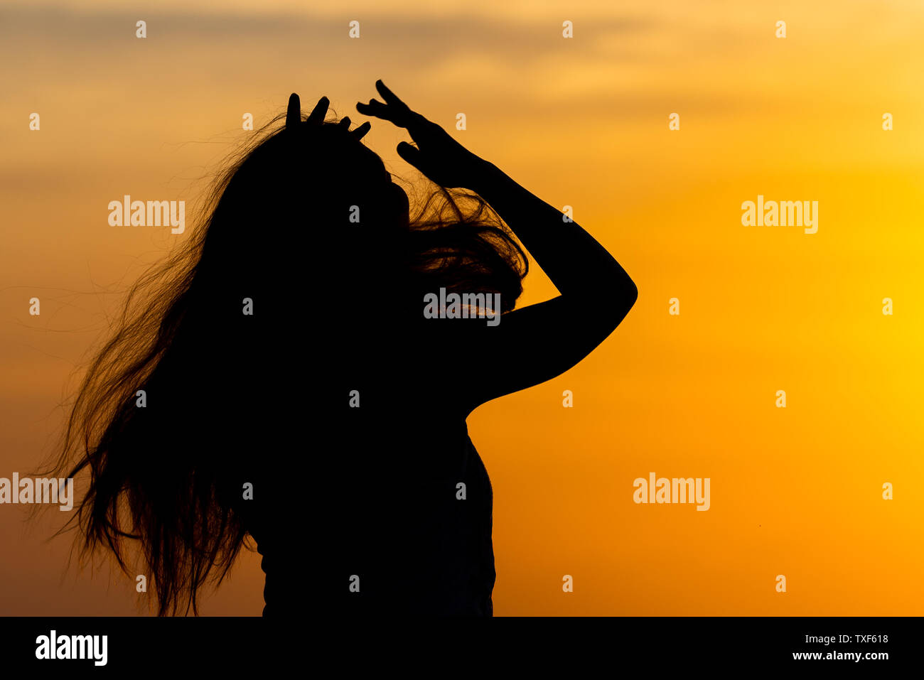 Silhouette of woman posing at yellow sunset Stock Photo - Alamy