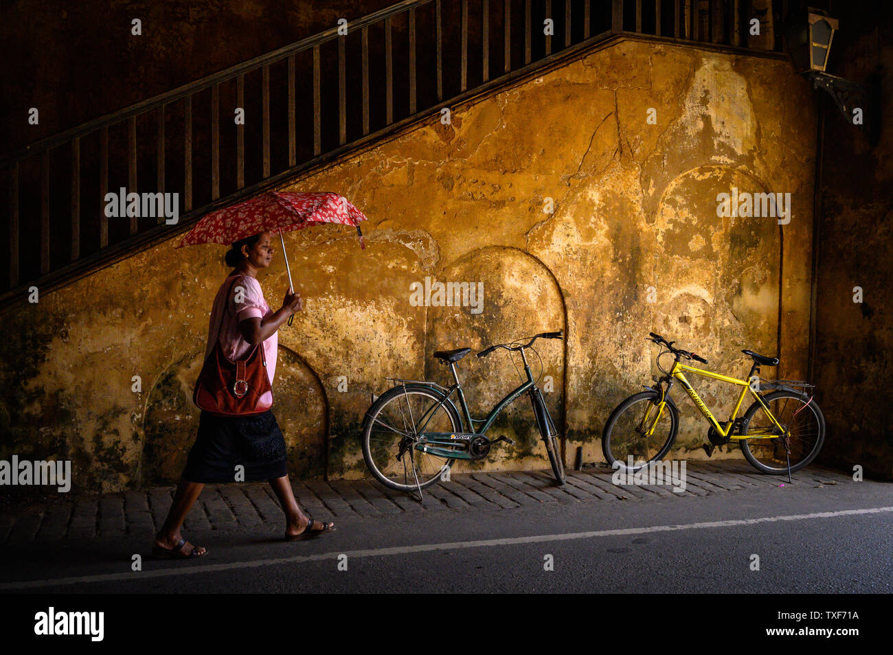 Woman walking with an umbrella in a tunnel in Galle, Sri Lanka Stock Photo
