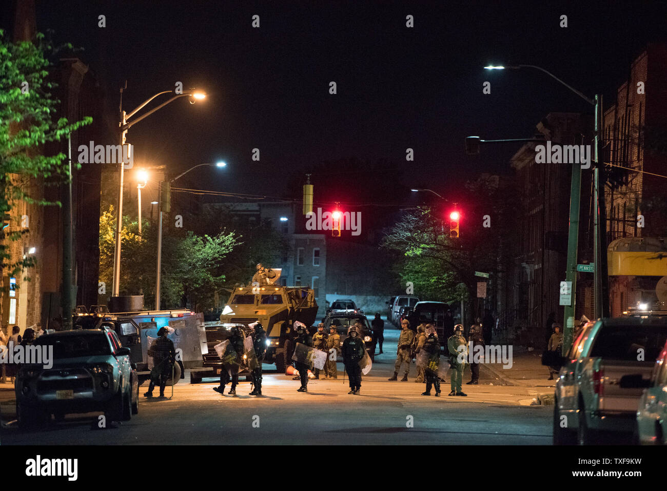 Police in riot gear line up with military rescue vehicle while local citizens pushed the limit of the 10 p.m. curfew in Baltimore, Maryland on April 28, 2015.  Protests have erupted after death of Freddie Gray.    Photo by Ken Cedeno/UPI Stock Photo