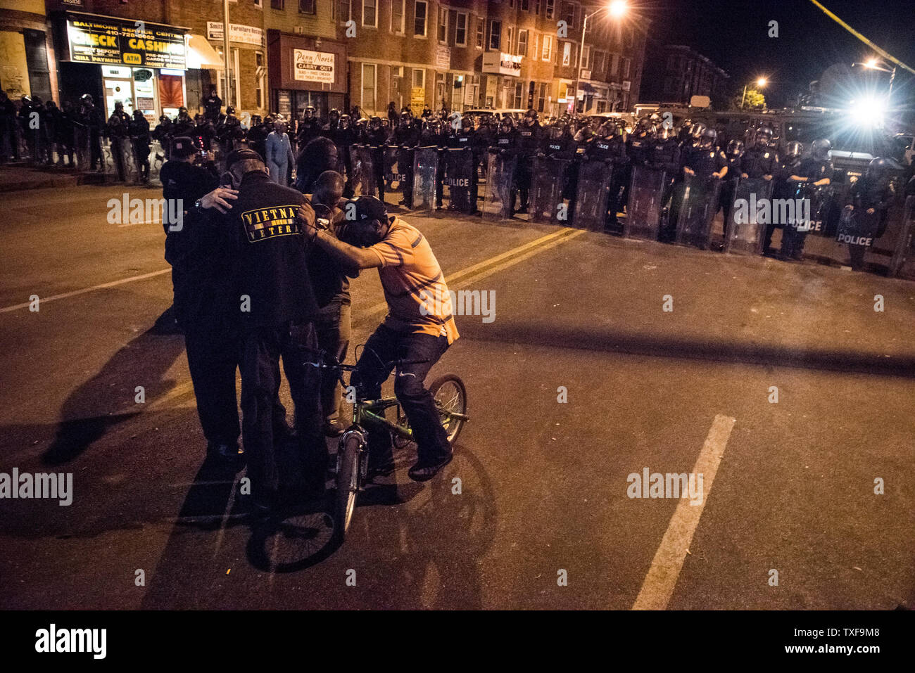 Local citizens gather and pray during demonstrations in Baltimore as the 10pm curfew grew closer in Baltimore, Maryland on April 28, 2015.  Protests have erupted after death of Freddie Gray.    Photo by Ken Cedeno/UPI. Stock Photo