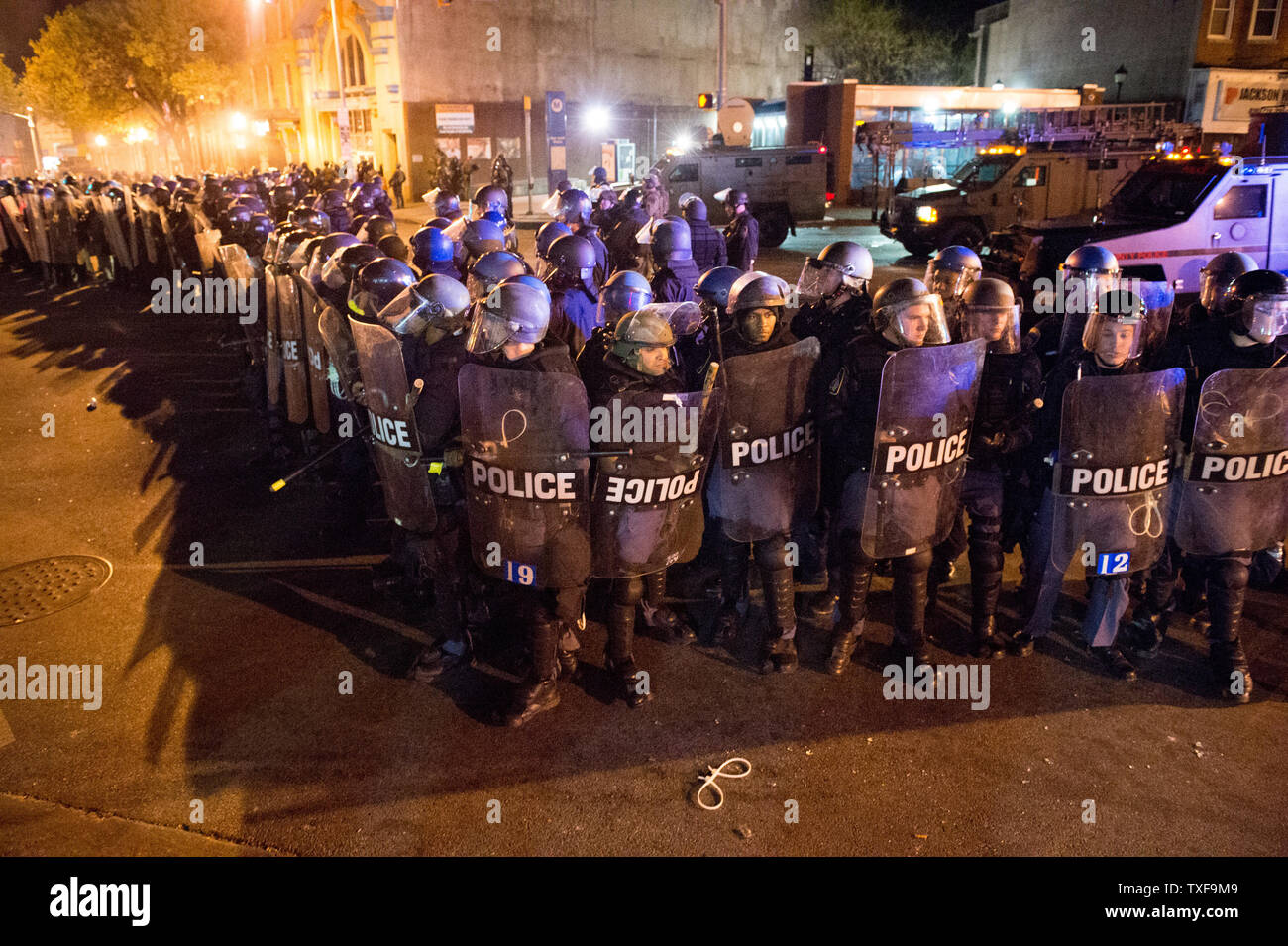 Police at the corner of Pennsylvania Ave and North Ave in Baltimore get ready as the 10 p.m. curfew approaches in Baltimore, Maryland  on April 28, 2015.  Protests have erupted after death of Freddie Gray.    Photo by Ken Cedeno/UPI. Stock Photo