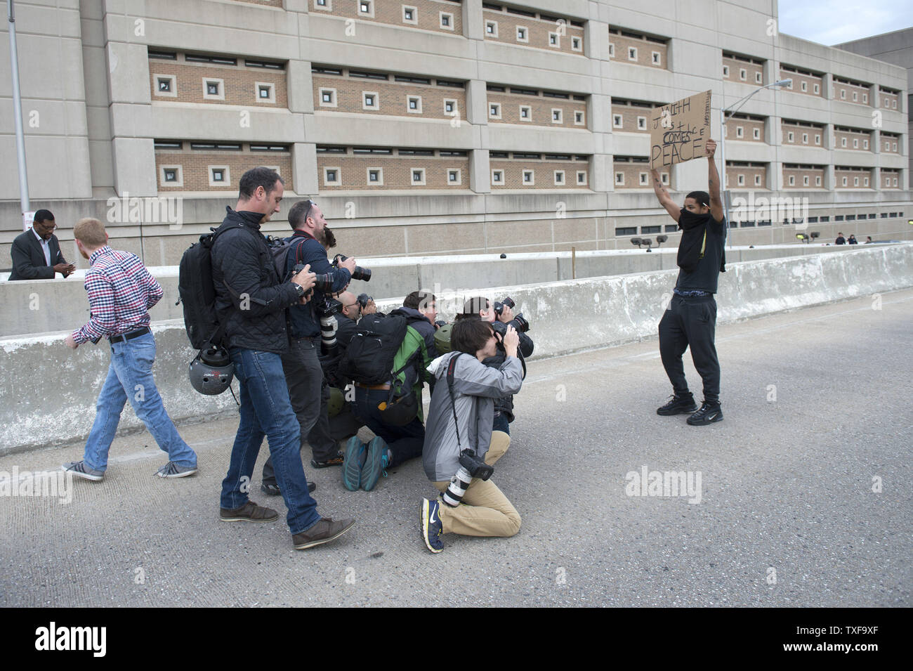 Photographers take pictures of Caron Carroll, 18, of Baltimore as he blocks an off ramp to rt 83 during the Black Lives Matter May Day Action Protest to show support for Freddie Gray and all arrested protesters, in Baltimore, Maryland, May 1, 2015. Baltimore City state's attorney Marilyn Mosby, announced earlier today that the death of Freddie Gray was a homicide and said the six arresting officers will be charged. Gray, 25, who was arrested on April 12, died a week later in the hospital from spinal cord injury he received while in police custody. Photo by Kevin Dietsch/UPI Stock Photo