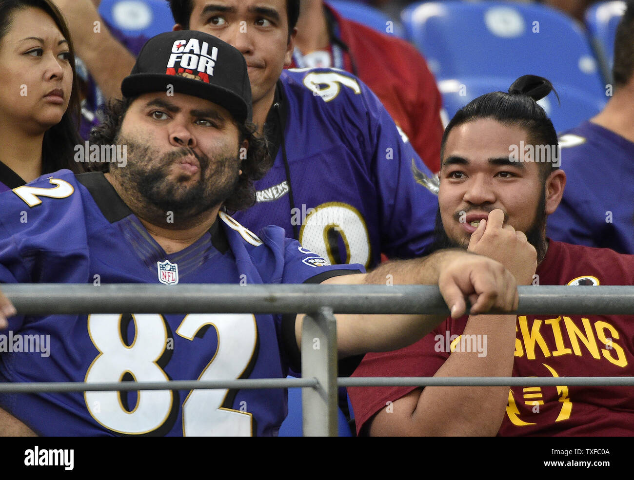 A Baltimore Ravens fan sits next to a Washington Redskins fan during the  first half of an NFL preseason game at M&T Bank Stadium in Baltimore,  Maryland, August 10, 2017. Photo by
