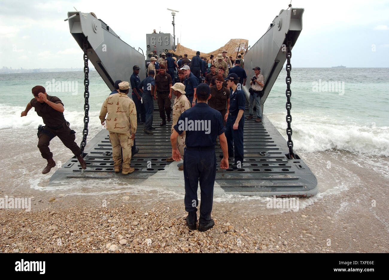 American nationals walk towards a U.S. landing craft on a beach north of  Beirut on July 21, 2006. The landing craft will transfer them to naval  ships which will take the them
