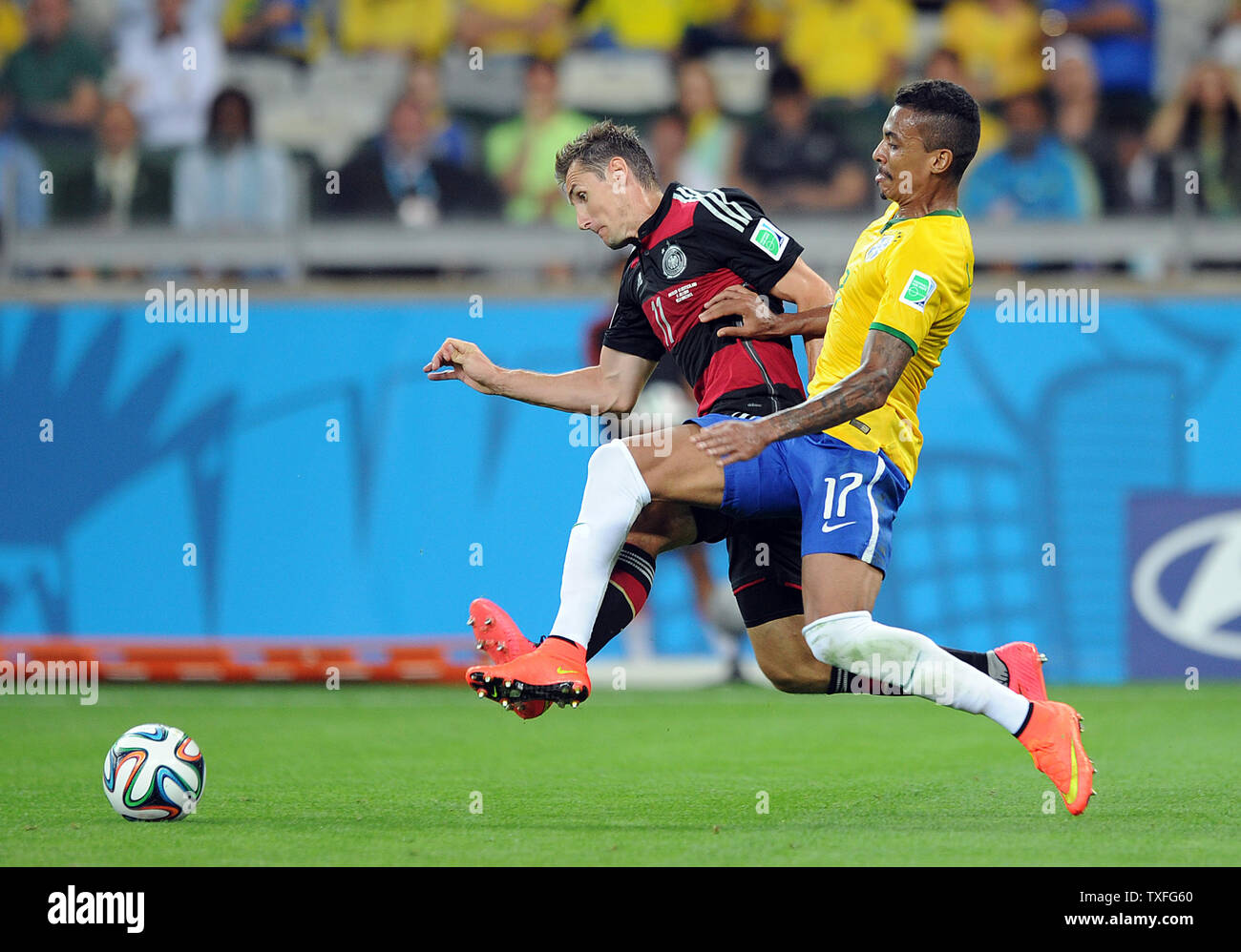 Luis Gustavo of Brazil competes with Miroslav Klose (L) of Germany during the 2014 FIFA World Cup Semi Final match at the Estadio Mineirao in Belo Horizonte, Brazil on July 08, 2014. UPI/Chris Brunskill Stock Photo