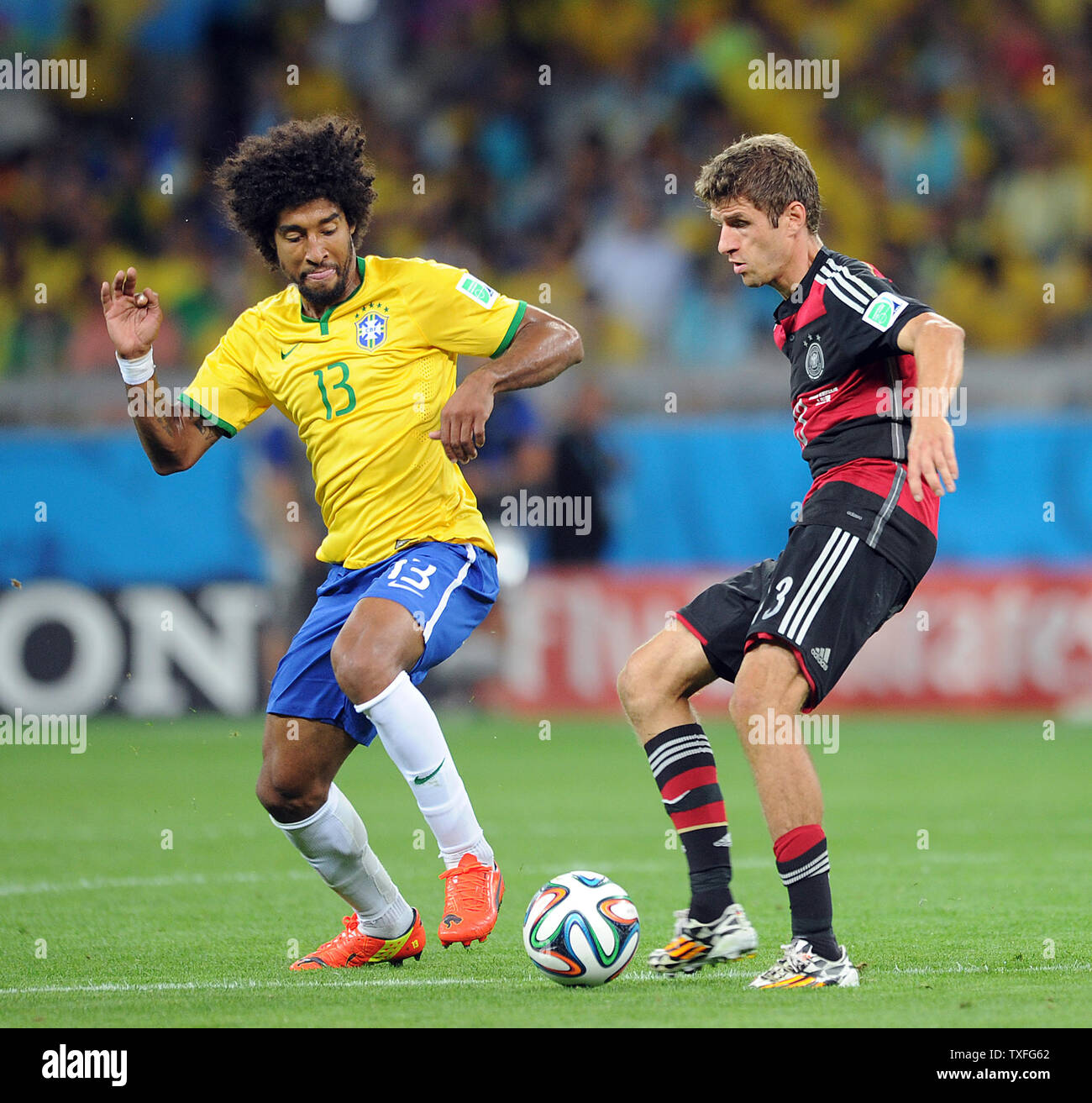 Dante (L) of Brazil competes with Thomas Muller of Germany during the 2014 FIFA World Cup Semi Final match at the Estadio Mineirao in Belo Horizonte, Brazil on July 08, 2014. UPI/Chris Brunskill Stock Photo