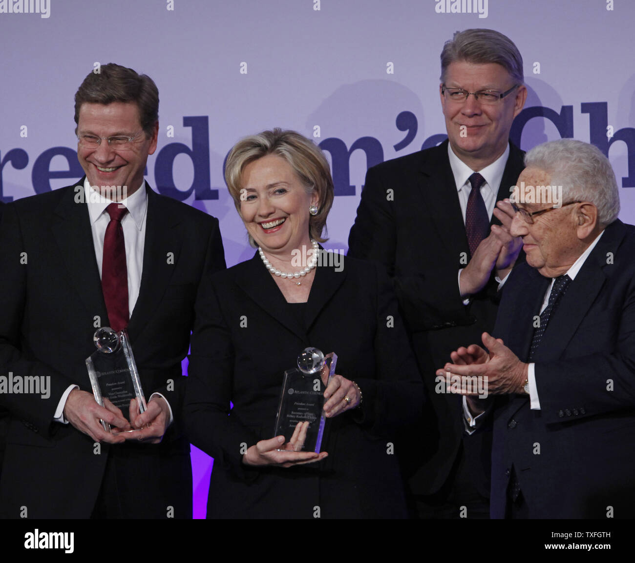(From L to R) German Foreign Minister Dr. Guido Westerwelle, U.S. Secretary of State Hillary Clinton, Atlantic Council President and CEO Frederick Kempe and former U.S. Secretary of State Dr. Henry Kissinger receive applause from the audience after the Freedom Challenge Dinner in Berlin on November 8, 2009.  Clinton and Westerwelle received the awards which recognizes individuals who have fought for democracy and liberty.  The event was held in conjunction with the 20th anniversary of the fall of the Berlin Wall which will be celebrated on November 9 in the German capital.   UPI/David Silpa Stock Photo