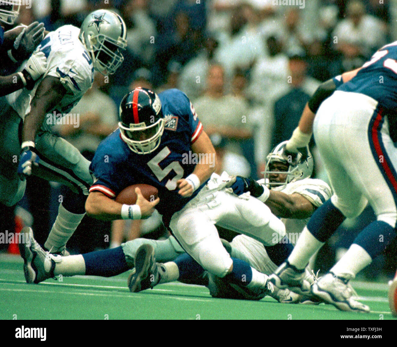 DAL2000010201 - 02 JANUARY 2000 - DALLAS, TEXAS, USA: New York Giants  quarterback Kerry Collins is sacked by Dallas Cowboy Leon Lett during the  second quarter of the Cowboys-Giants game. The Cowboys