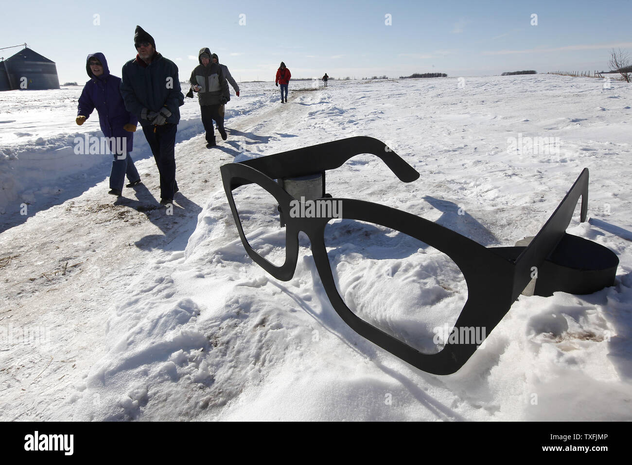 Rock 'n' roll fans walk by a giant pair of Buddy Holly glasses as they visit the site of the plane crash that killed Holly, Ritchie Valens and J. P. 'The Big Bopper' Richardson near Clear Lake, Iowa on February 2, 2009. Singer Don McLean coined the phrase 'the day the music died' in his hit song American Pie referring to the death of the three rock 'n' roll pioneers in the early morning hours of February 3, 1959. Thousands of people descended upon Clear Lake to celebrate the 50th anniversary of 'the day the music died'.   (UPI Photo/Brian Kersey) Stock Photo